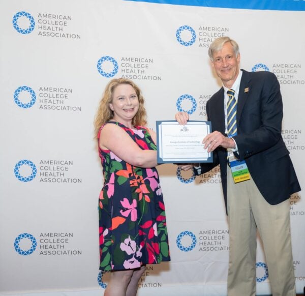 Two professional people posing with an award certificate