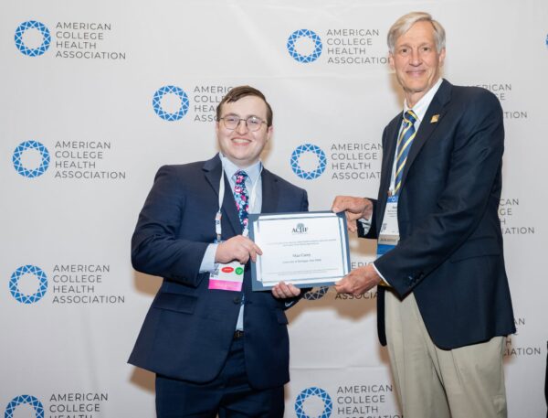 Two professional people holding an award certificate and shaking hands