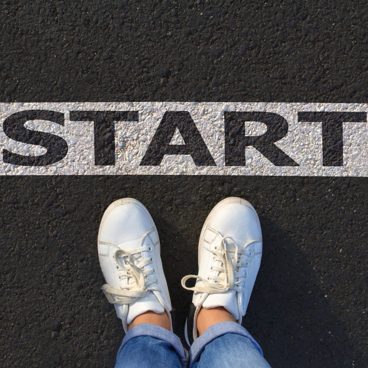 A zoomed in shot of a person standing at the start line on a street