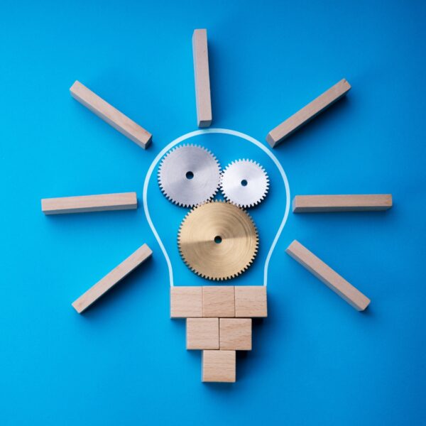 The shape of a lightbulb created with building blocks with metal gears inside the bulb