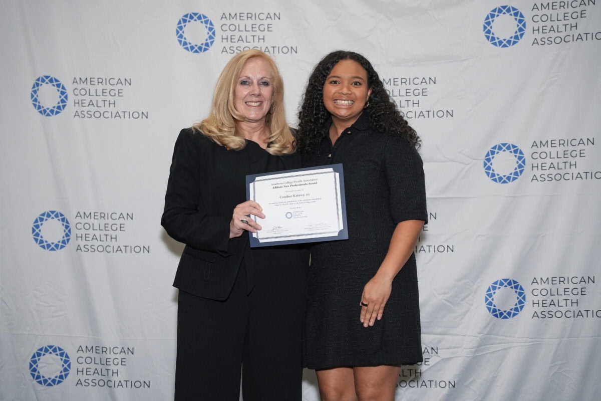 ACHA Awards Committee Chair Passing an Award Certificate to an Award Recipient