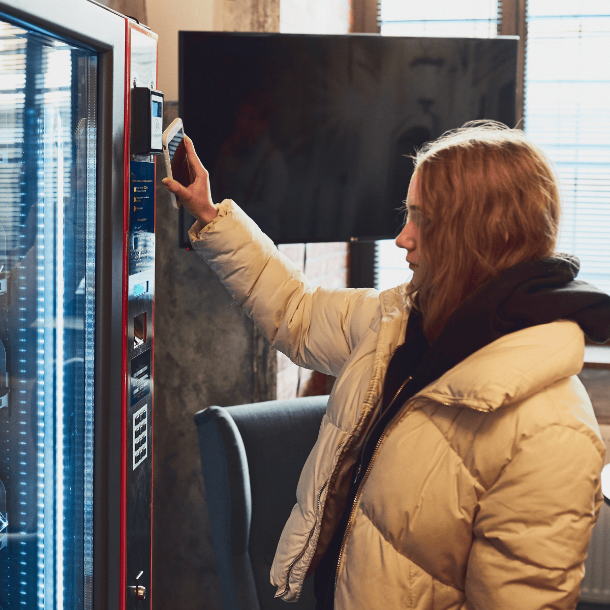 A student using her phone to make a purchase from a vending machine