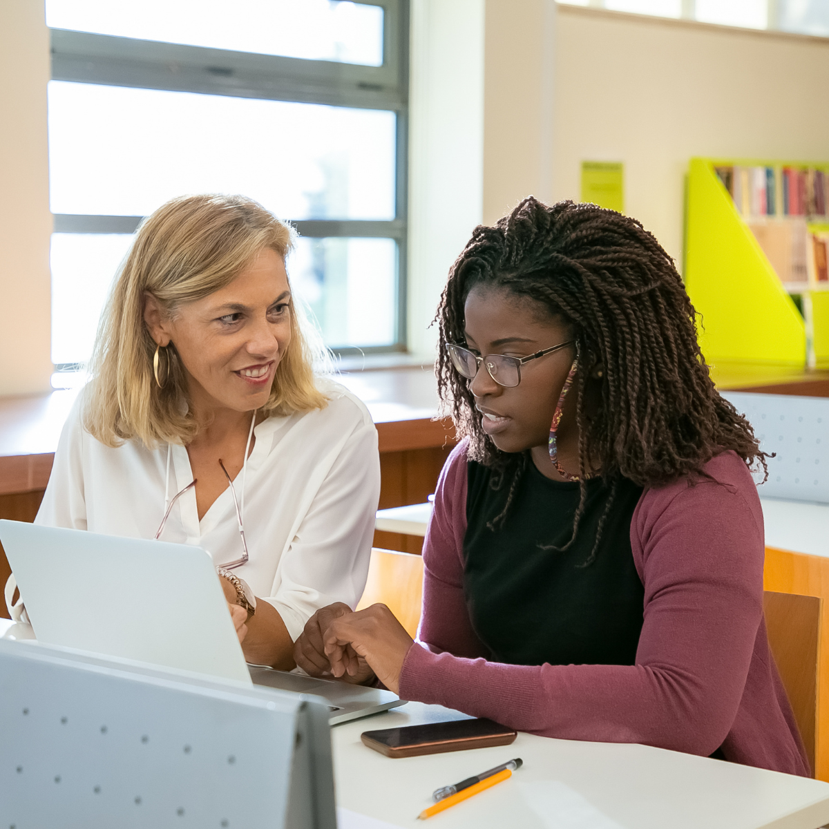 College student and a campus professional seated together in front of a laptop