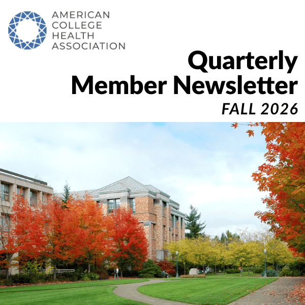 A college campus with buildings, a green lawn, and trees changing color for the fall