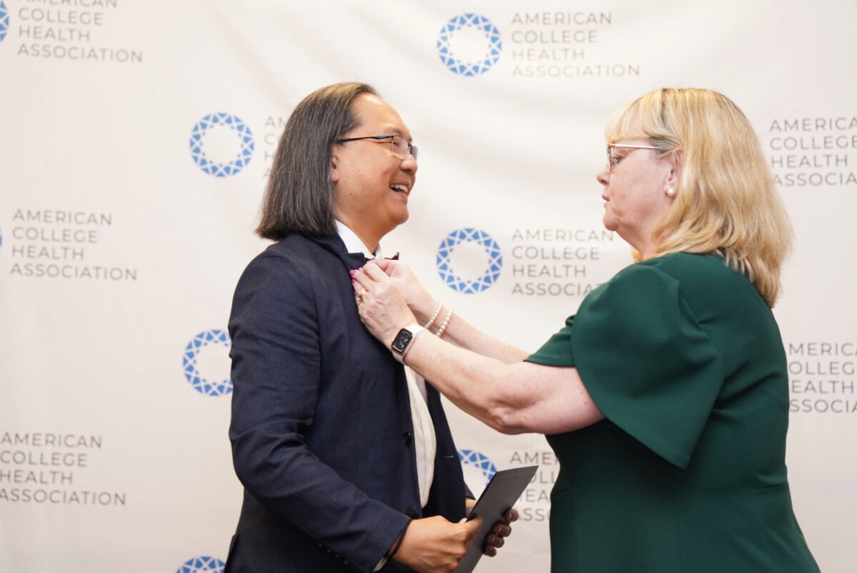 Katrin Wesner-Harts presenting Giang Nguyen with an ACHA Fellows pin