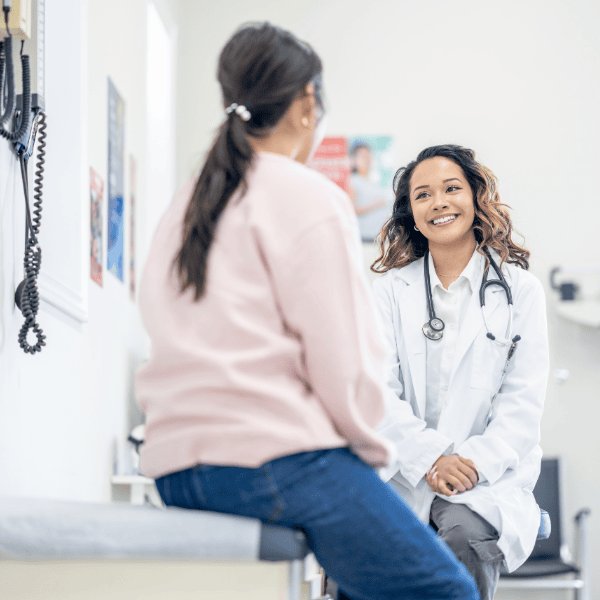 happy clinician talking to a student in an exam room