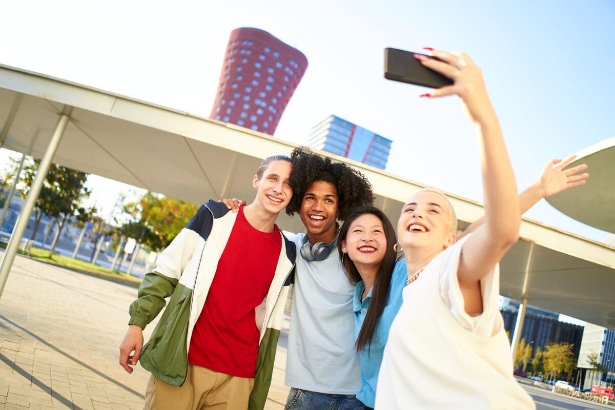 A group of young people outside in the city taking a selfie