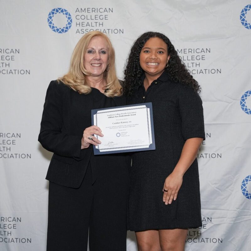 ACHA Awards Committee Chair Passing an Award Certificate to an Award Recipient