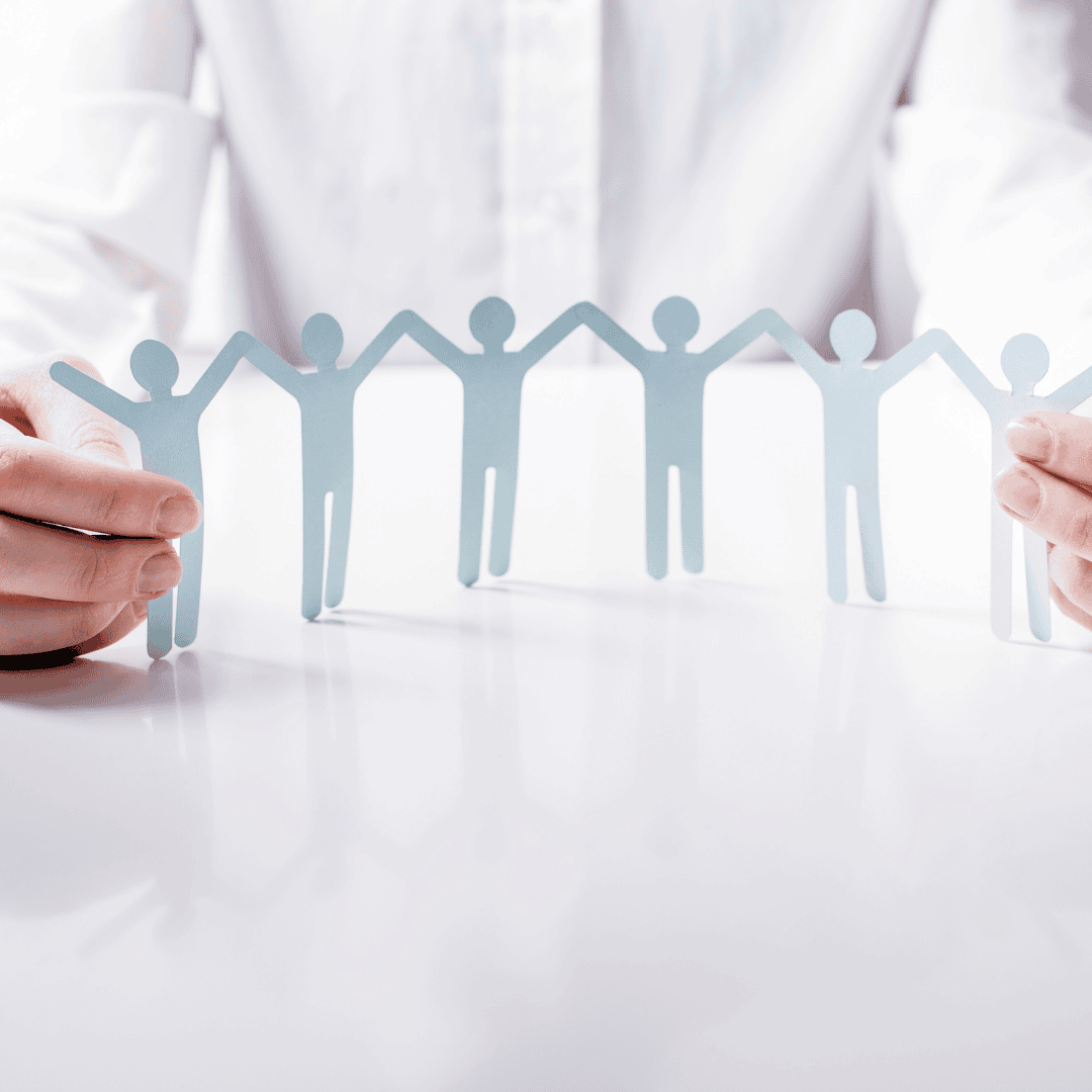 A professional holding a paper train of people on a table