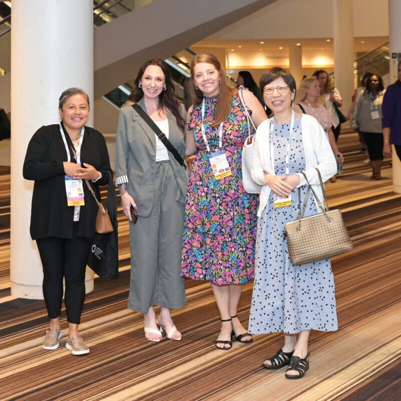A group of women at the ACHA annual meeting standing together and smiling