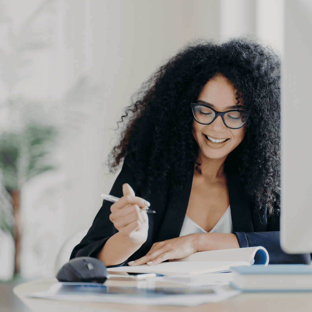 Smiling curly-haired female professional working at a table