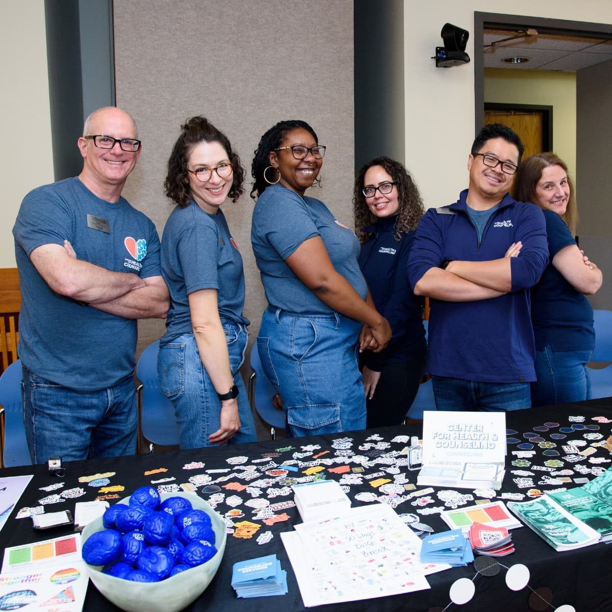 A smiling group of health and counseling center professionals at a campus health fair
