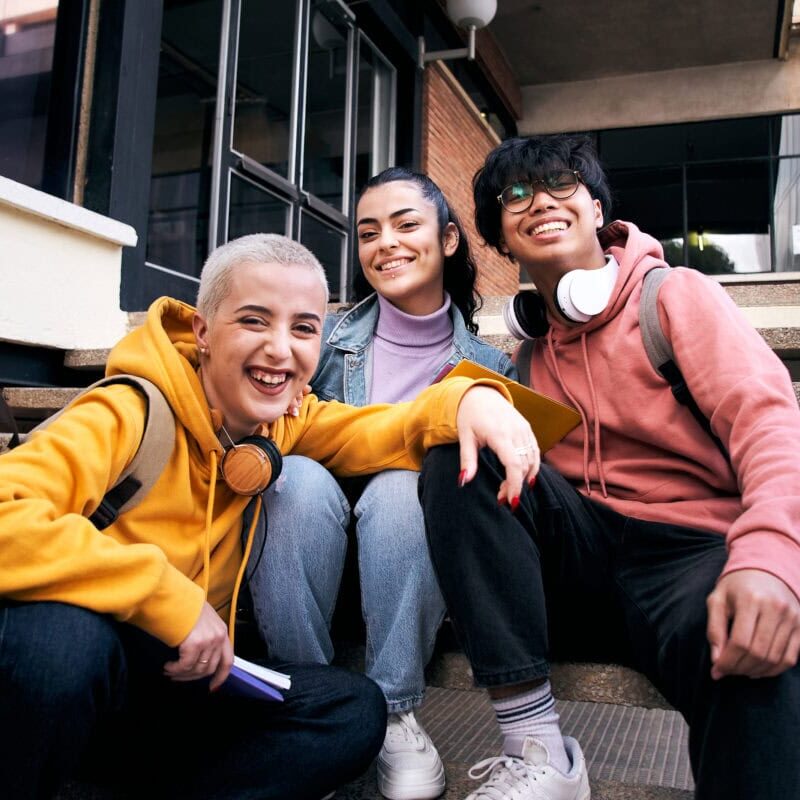 Group of three students outside the school looking at the camera