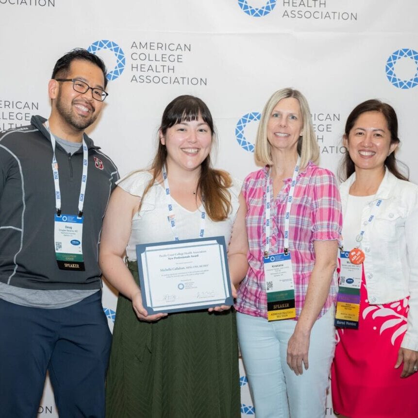 Group of people posing with an award winner holding a certificate