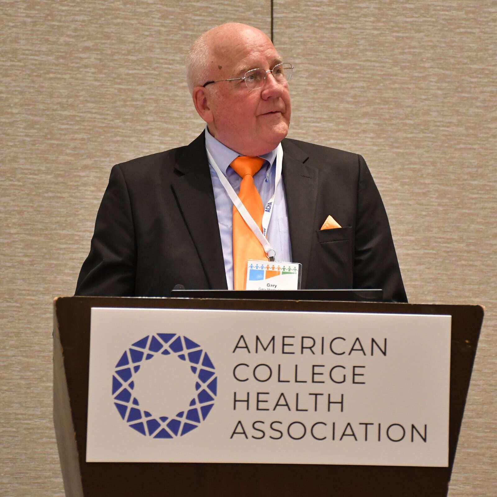 Gary MacLachlan delivering a speech at a podium