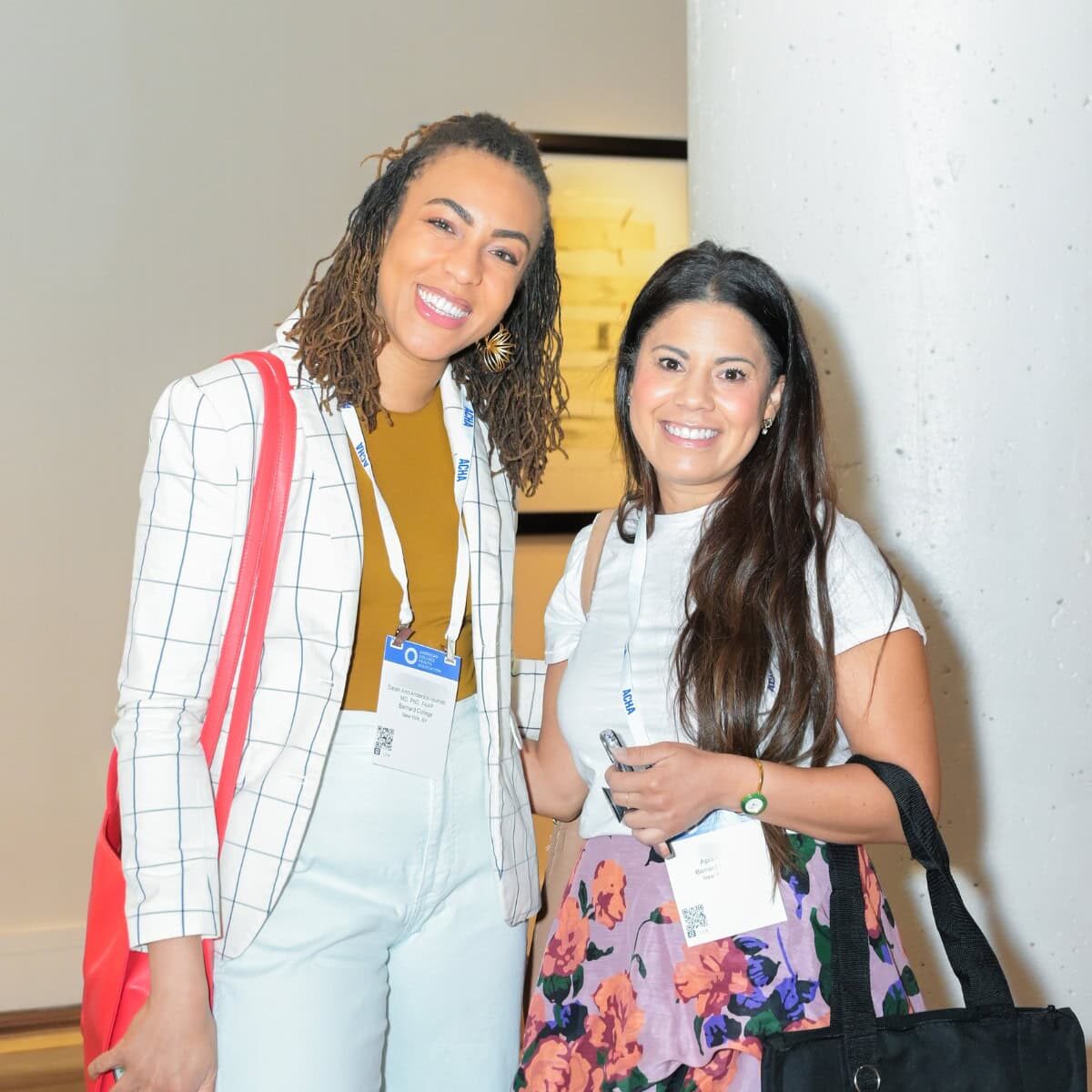 Two smiling female professionals at a conference