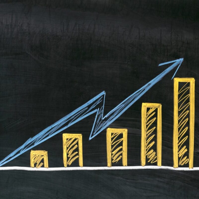 A bar graph depicting an increasing trend written in yellow chalk on a chalkboard