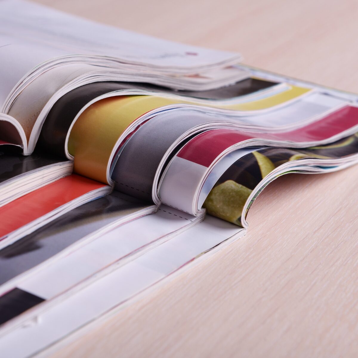 Several magazines stacked on top of each other on top of a table