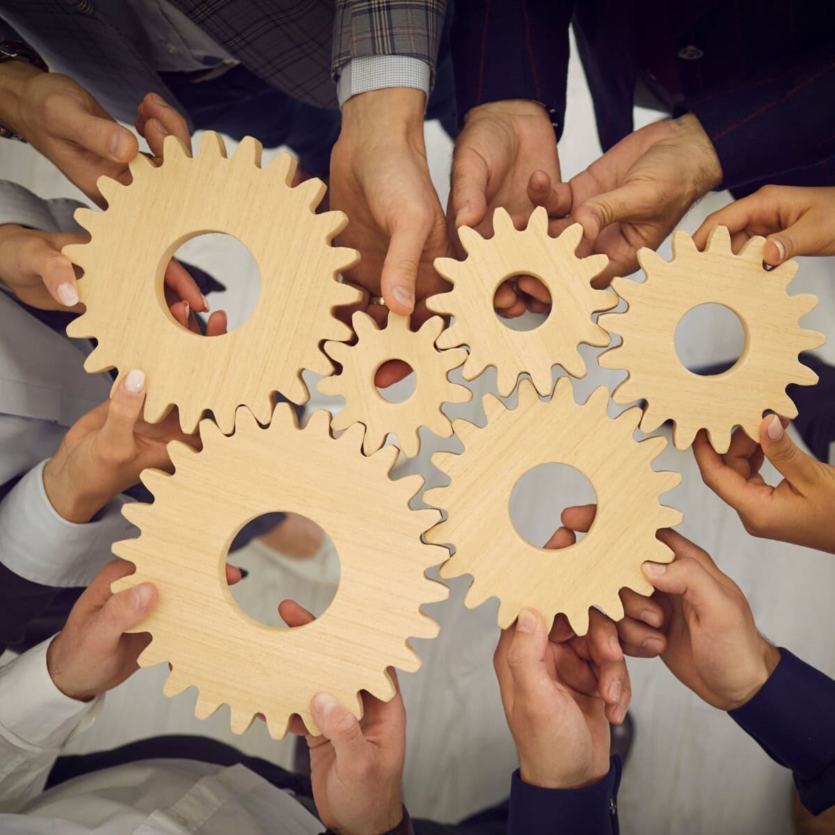 Group of professionals standing together and holding gear symbols