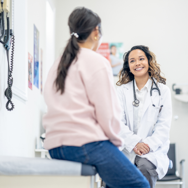happy clinician talking to a student in an exam room