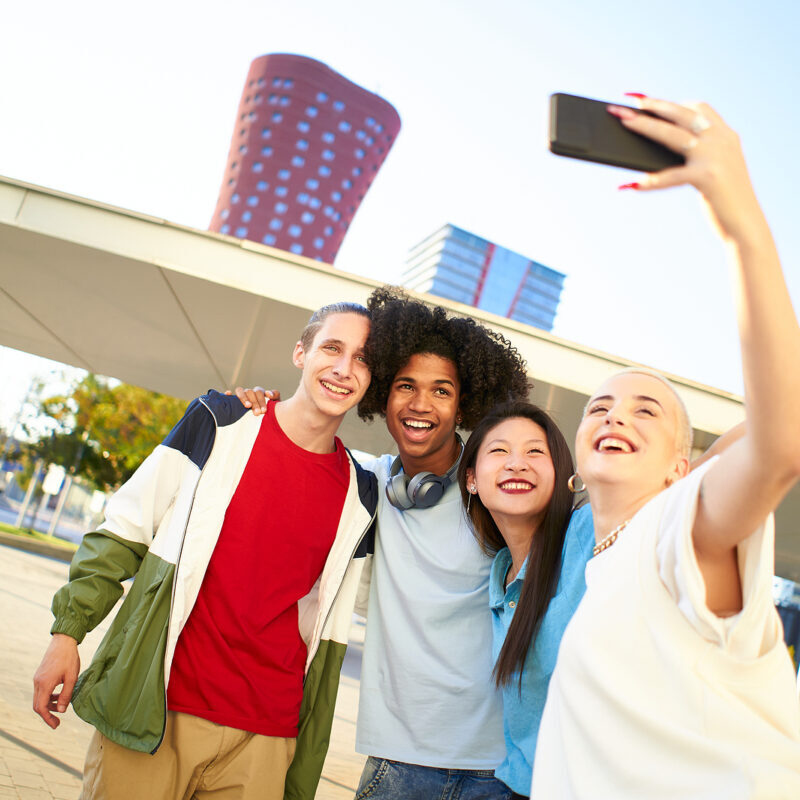 A group of young people outside in the city taking a selfie